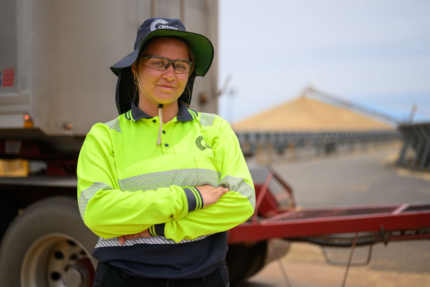 female with arms crossed in high visibility clothing and hat