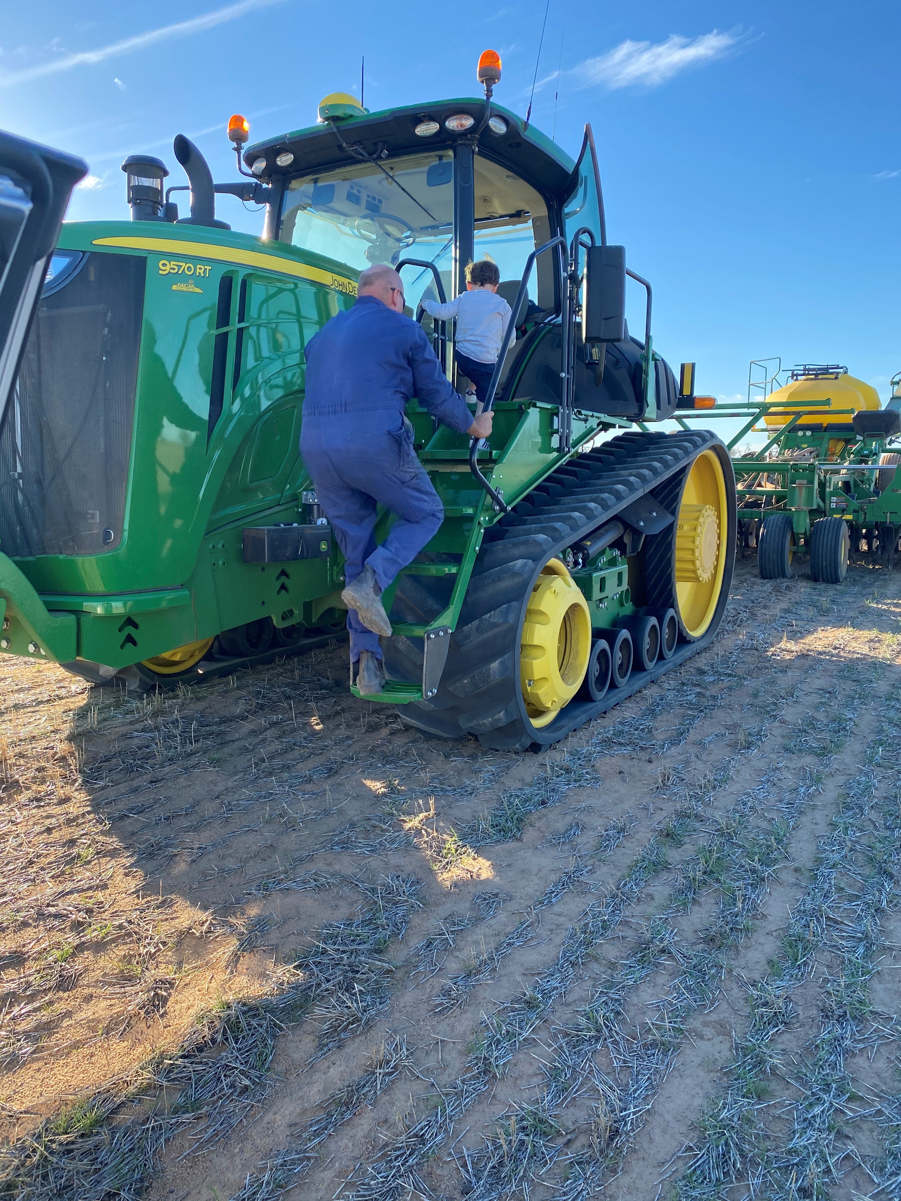 Pop and grandson climb onto tractor
