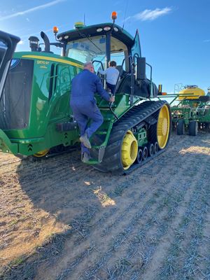 Pop and grandson climb onto tractor