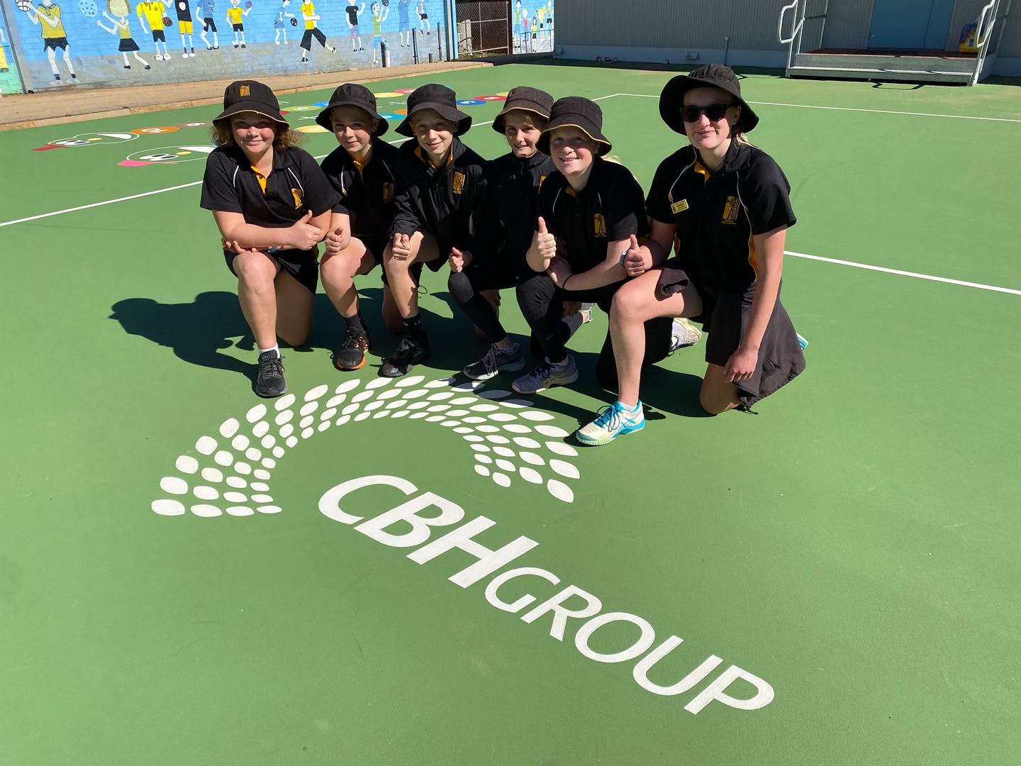 School children on basketball court with CBH logo