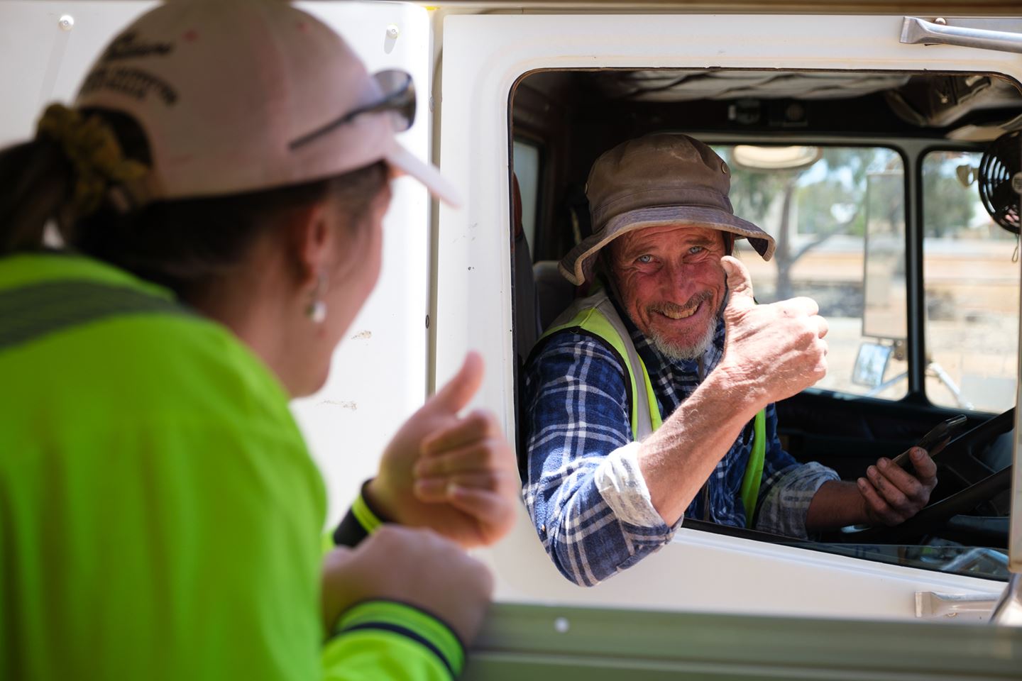 A truckie gives a thumbs up to the CBH sampler through the window of the sample hut on site during harvest