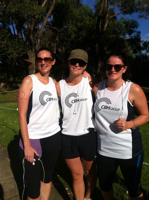 Three women stand together after a running race