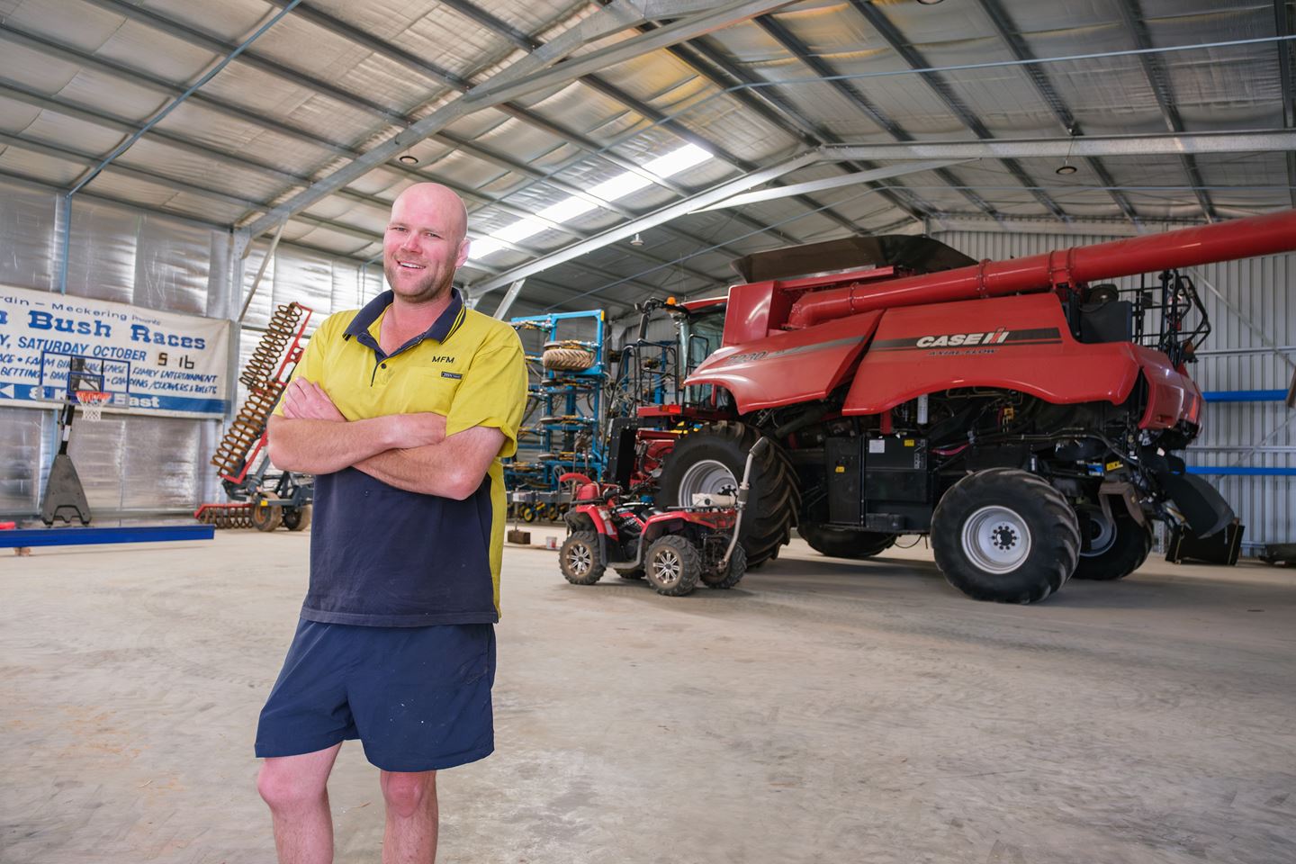 Two men in blue shirts standing in paddock inspecting crop